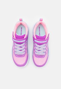 Baskets de sport violettes avec une tige en mesh respirant, des accents roses, des lacets bleu clair et une sangle en Velcro. Logo notable sur la sangle.