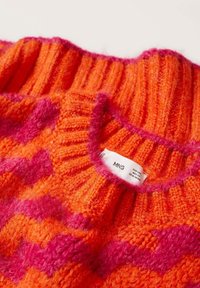Col de pull en tricot avec un motif chevron côtelé orange et rose, comportant une étiquette en tissu blanche marquée "MNG".