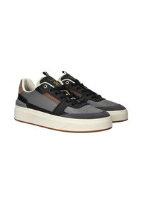 Grijze en zwarte sneakers met een gestructureerde bovenkant, subtiele bronzen accenten, een witte zool en zwarte veters. Heeft perforaties op de teen.