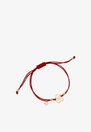 Czerwony sznurkowy bransoletka z złotym urokiem w kształcie kwiatu i dwoma złotymi koralikami. Regulowany design z węzłem zapewniającym pewne dopasowanie.