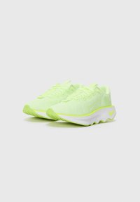 Chaussures de sport vert lime avec un dessus en mesh texturé, semelle intermédiaire blanche et semelle extérieure ondulée. Comprend des accents réfléchissants et des lacets ronds.