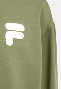 Sudadera de color verde oliva con un logo texturizado en blanco. La tela es suave y lisa, con un corte relajado y cuello redondo.