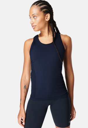 Marineblauw sporttanktop met ronde hals, mouwloos ontwerp, gladde stof en mesh zijpanelen voor ademend vermogen. Gecombineerd met donkere shorts.