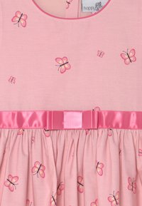 Różowa sukienka z motywem motyli, wyposażona w satynowy pasek. Materiał jest miękki, z marszczoną spódnicą i zaokrąglonym dekoltem.