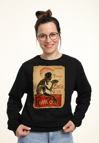 Felpa nera con stampa grafica di un design di zombie scheletrico e testo su uno sfondo beige, colletto rotondo e vestibilità comoda.