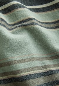 Soft fabric with wavy texture featuring horizontal stripes in muted green, beige, and dark blue tones.