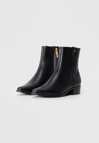 Stivaletti neri in pelle con punta appuntita, zip laterale e tacco a blocco piccolo. Presentano hardware dorato e dettagli con logo discreto.