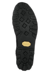 Semelle en caoutchouc noir avec des rainures profondes présentant des motifs floraux et géométriques. Logo "Vibram" doré affiché de manière proéminente sur le côté.