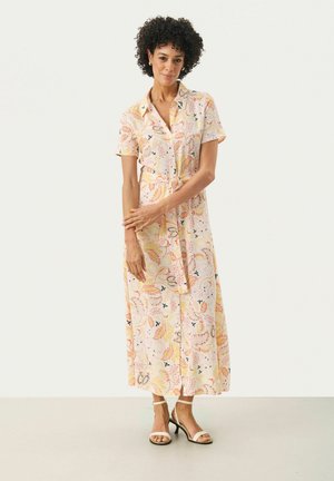 Knoopdown, jurk met korte mouwen in lichtroze stof. Heeft een bloemenpatroon in oranje en blauwe tinten, met een tailleband en een enkel lengte zoom.