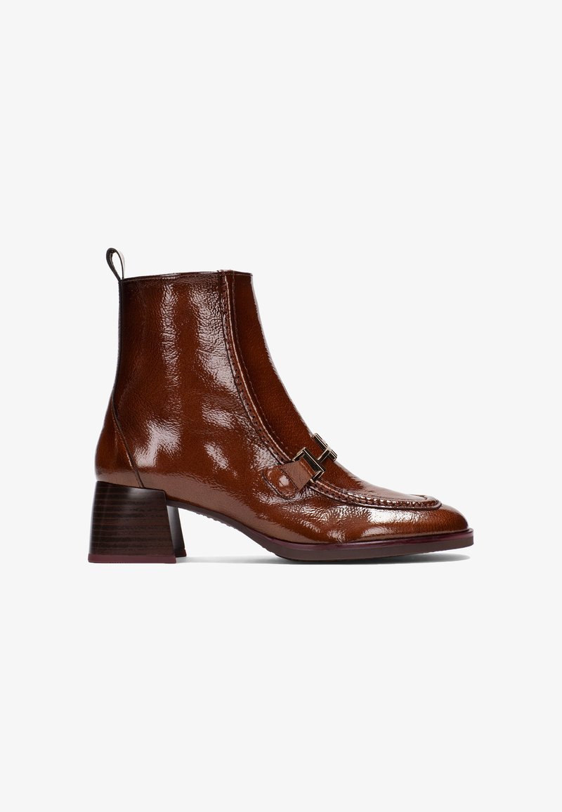 Brązowe lśniące skórzane botki za kostkę z zaokrąglonym noskiem, ozdobnymi zapięciami oraz kwadratowym średnim obcasem. Gładka faktura i elegancki design.