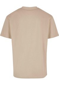 Lys beige bomull t-skjorte med korte ermer og rund hals. Glatt tekstur og ingen synlige mønstre eller grafikk på baksiden.