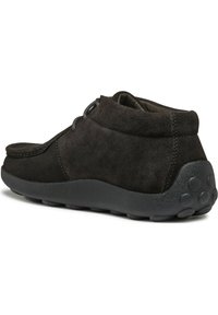 Stivali alla caviglia in suede nero con punta rotonda, dotati di un collo imbottito e di una suola in gomma texturizzata per una migliore aderenza. Inclusi accenti di cucitura sottili.