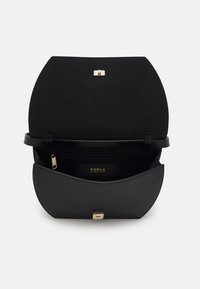 Czarna skórzana torebka na ramię z zakrzywioną klapą, złotymi elementami metalowymi i kieszenią na zamek wewnątrz. Charakteryzuje się gładką fakturą i stonowanym designem.