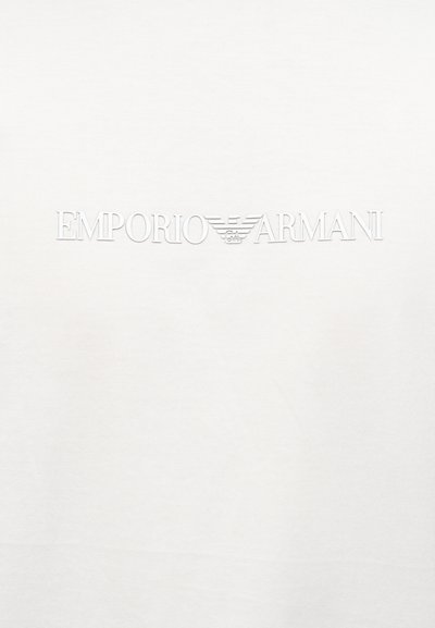Λευκό ύφασμα με το όνομα της μάρκας Emporio Armani και το λογότυπο αετού σε ανάγλυφη μορφή στο κέντρο, στο ίδιο λευκό χρώμα.