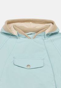 Ανοιχτό γαλάζιο μπουφάν με μπεζ ριγέ επένδυση κουκούλας, εμπρόσθια τσέπη με μεταλλικό κούμπωμα και λεία εξωτερική υφή.