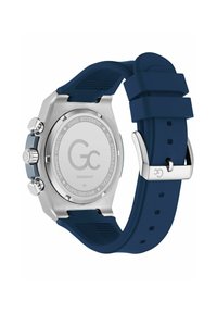 Sudraba nerūsējošā tērauda pulkstenis ar tumši zilu silikona siksniņu, kuram ir teksturēta virsma, hronogrāfa detaļas un safīra kristāla aizmugure.