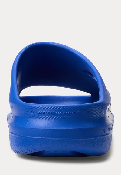 Μπλε λαστιχένιο σάνδαλο χωρίς κορδόνια με λουράκι, εμφανιζόμενο από πίσω, τονίζοντας την περιοχή της φτέρνας και την υφή της σόλας.