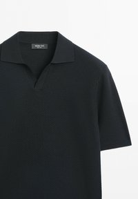 Polo noir texturé à manches courtes avec col et ouverture en V, étiquette Massimo Dutti.