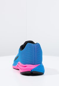 Modré sportovní boty z prodyšné síťoviny s černými akcenty a růžovou podešví. Mají polstrovaný límec a texturovaný design na boku.