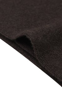 Tessuto di lana marrone con una consistenza morbida e un orlo leggermente ripiegato, che mostra un motivo a maglia e lievi variazioni di colore.