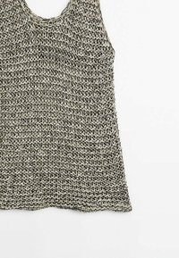 Haut sans manches en tricot avec larges bretelles en fil noir et écru présentant un motif texturé et tissé de manière lâche.