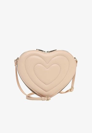 Beige heart-shaped crossbody bag with quilted heart patterns, gold-tone zipper, and adjustable strap on a white background.