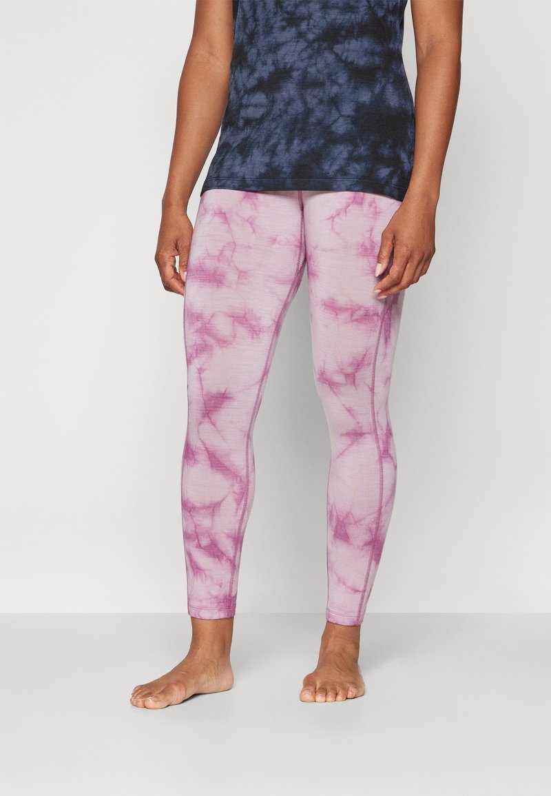 Ružové legíny s tie-dye vzorom vyrobené z mäkkého, elastického materiálu, s priliehavým strihom a švovými akcentmi. V páre s námořnícko-modrým tielkom s tie-dye vzorom.