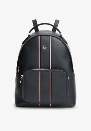 Zaino in pelle nera testurizzata con tasca frontale con cerniera, doppie strisce verticali rosse e bianche, cerniera tono oro e logo TH su pannello frontale liscio.