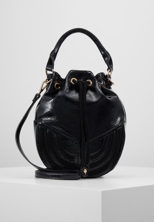 Sac seau en cuir verni noir avec une poignée supérieure, fermeture à cordon, œillets dorés, coutures géométriques et bandoulière amovible.