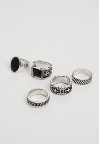 Set of five silver rings featuring various designs: one has a black stone, others display textured and patterned finishes.