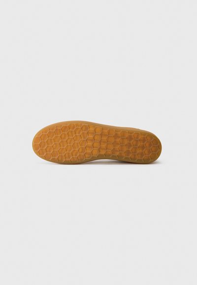 Suola di scarpa in gomma con un motivo esagonale, di colore marrone chiaro e texture liscia; progettata per offrire aderenza e trazione.