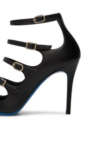 Scarpa nera con tacco alto e più cinture decorative. Presenta un nella superiore in pelle testurizzata, fibbie dorate con accenti di strass e una suola blu.