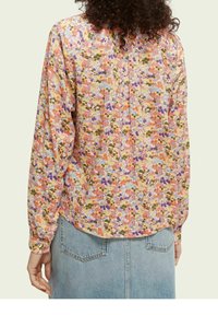 Květinová blůza má ví couleurs vzor v odstínech růžové, oranžové a zelené. Dlouhé rukávy, uvolněný střih a zakulacený lem.