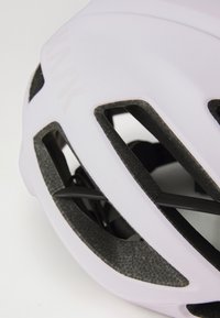 Nahaufnahme eines hellpurpurnen Fahrradhelms, der Belüftungsöffnungen und eine strukturierte Innenseite für Komfort und Sicherheit aufweist.