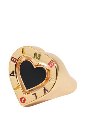 Anillo de oro con forma de corazón con un corazón central de esmalte negro y letras coloridas que forman la palabra "AMBIVALOR" alrededor del borde.