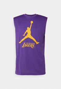 Débardeur violet avec silhouette jaune d'un joueur de basket sautant et tenant le ballon au-dessus de la tête et texte "Los Angeles Lakers" en dessous.