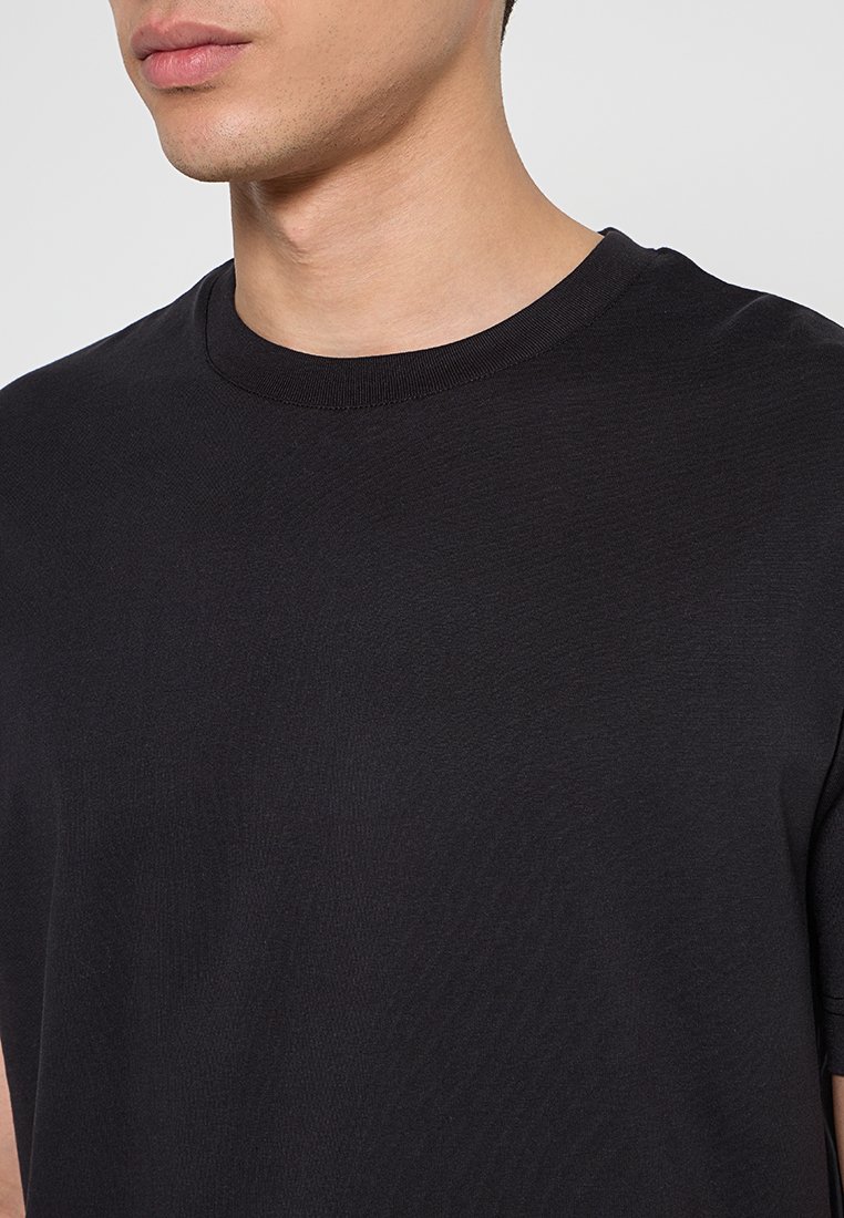 Czarna bawełniana koszulka z okrągłym dekoltem, krótkimi rękawami i gładką teksturą. Prosty design bez wzorów lub akcentów.