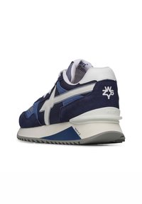 Navyblaue Wildleder-Sneaker mit weißen und hellblauen Akzenten, retro Design, strukturierten Einsätzen, erhöhter Sohle mit grauen Details und Logo auf der Ferse.