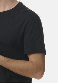 Svart bomullströja med rund halsringning och korta ärmar. Tyget ser slätt ut och passformen är avslappnad. Inga synliga mönster eller motiv.