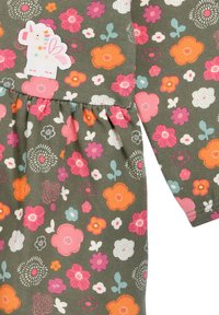 Mädchenkleid aus grünem Stoff, verziert mit bunten Blumen in Pink, Orange, Weiß und Blau, mit einem aufgenähten Einhorn-Detail.