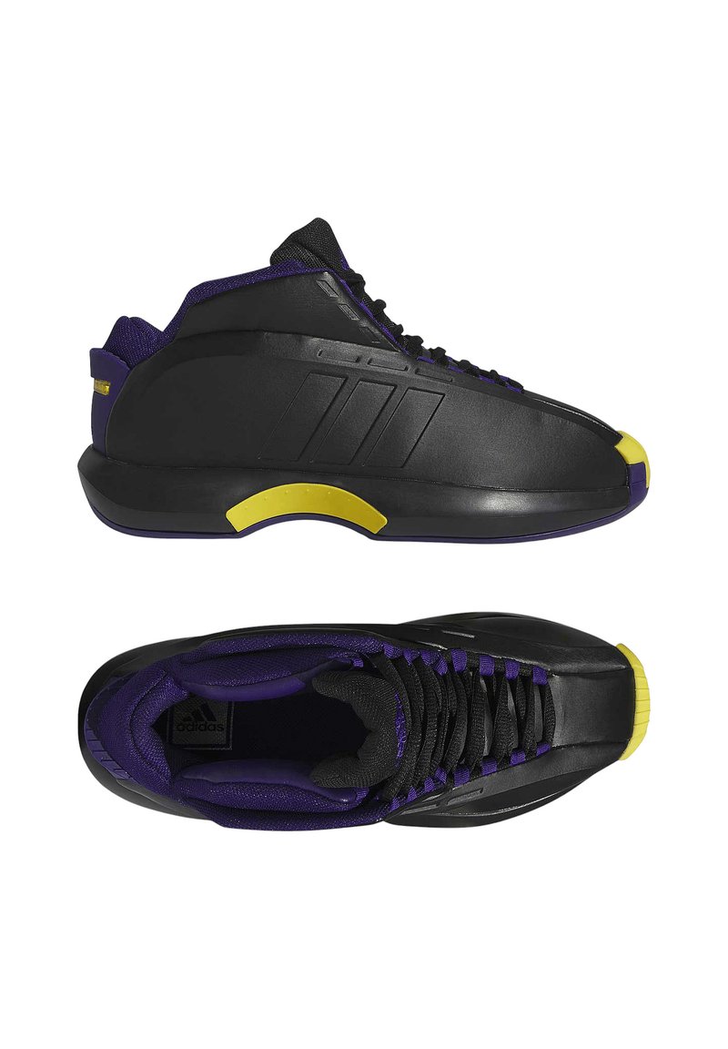 Zwarte sportschoenen met een slank ontwerp, voorzien van paarse accenten, een gele neuskap en een textuur bovenwerk. Zwarte veters passen bij de kleurencombinatie.