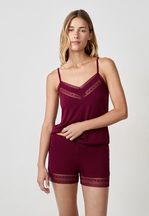 Ensemble de sommeil bordeaux comprenant un débardeur avec un délicat bord en dentelle et un short assorti avec des accents en dentelle à l'ourlet, fabriqué à partir d'un tissu doux.