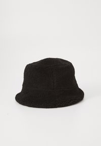 Cappello a secchiello nero realizzato in morbido pile testurizzato. Presenta una visiera ampia e una costruzione senza cuciture per una vestibilità comoda.