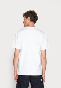 White cotton t-shirt with a crew neck, short sleeves, and a relaxed fit. No patterns or logos are visible. The fabric appears smooth.