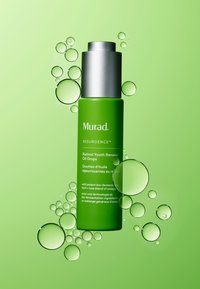 Grön flaska med Murad Retinol Youth Renewal Oil Drops, med en silverlock. Texturerad yta, omgiven av gröna bubblor mot en ljusgrön bakgrund.