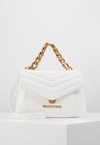 Vit läderhandväska med pessar mönster, guldkedja handtag, logotyp på framsidan, och avtagbar axelrem.