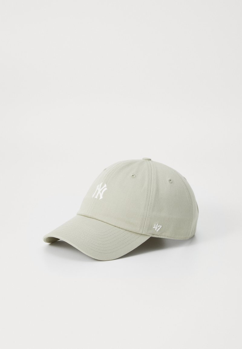 Lichtgroene baseballpet van stof met een textuurafwerking, voorzien van een wit geborduurd logo en een klein label aan de zijkant.