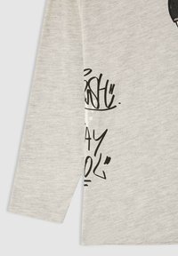 Maglietta a maniche lunghe grigia in cotone morbido, con testo e accenti grafici in stile graffiti neri. Presenta un collo rotondo e polsini cuciti.