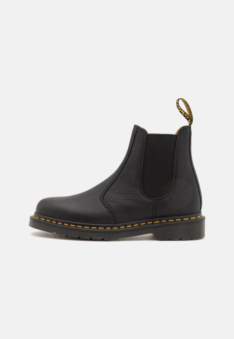 Bottes Chelsea en cuir noir avec panneaux élastiques sur les côtés, surface texturée, couture jaune autour de la semelle et une languette au talon.