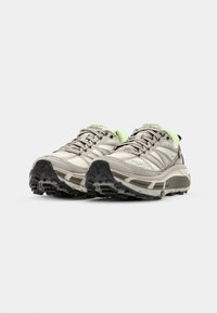 Gray and light green athletic shoes with mesh upper, lace closure, and rugged black outsole designed for traction on varied surfaces.